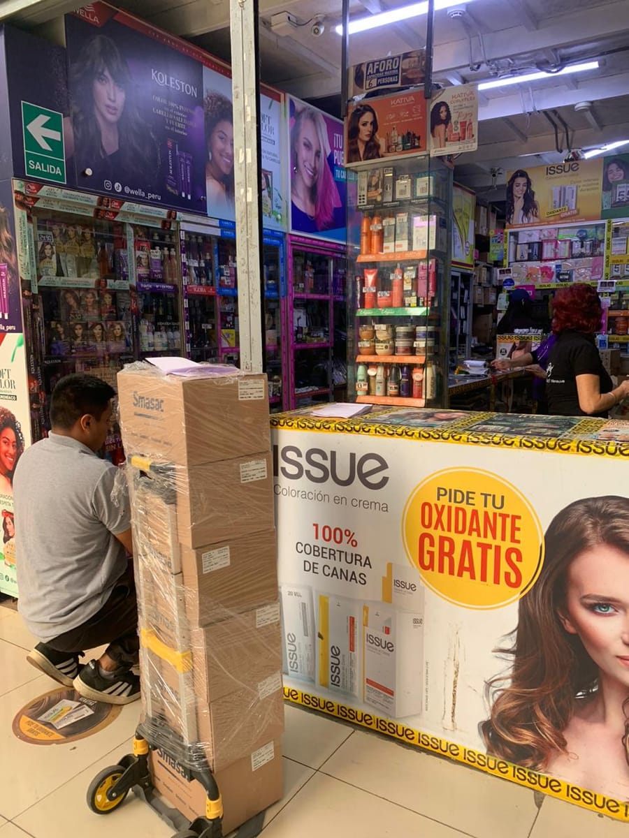 Reparto de pedido de talcos con carretilla en galería del Mercado Central